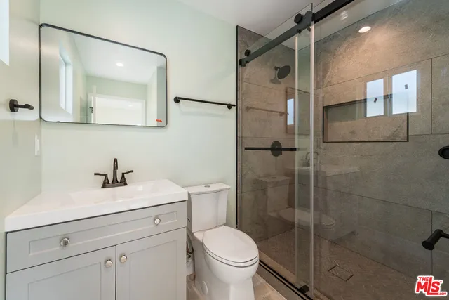 a bathroom with a toilet sink vanity and mirror