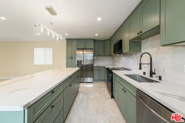 a large kitchen with stainless steel appliances lots of counter top space