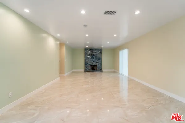 a view of an empty room with a kitchen