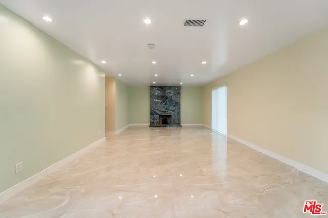 a view of an empty room with a kitchen