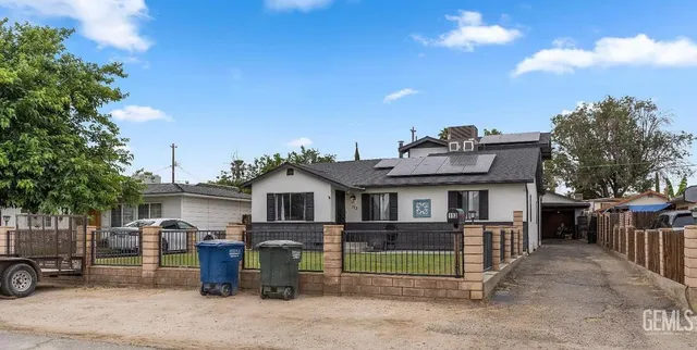 a front view of a house with a garden and parking space
