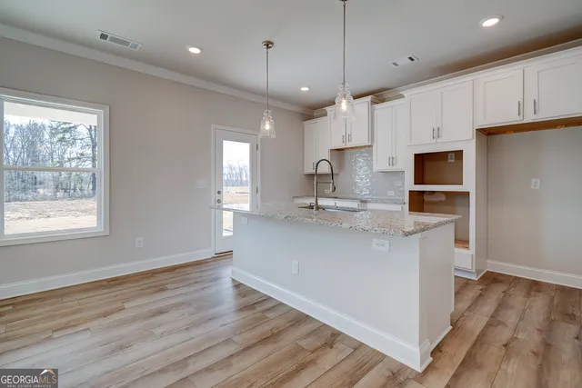 a kitchen with kitchen island a sink stainless steel appliances and cabinets