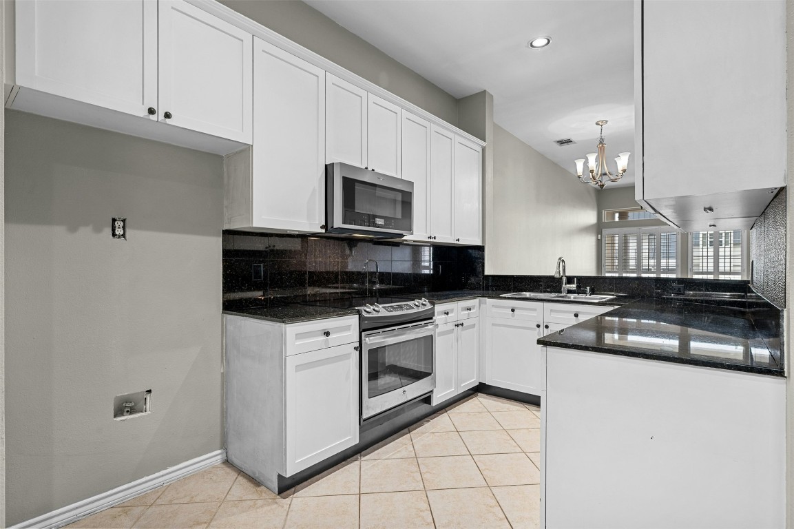 2918 Ranch Road 620 North, Unit W219 Austin, TX 78734 - Photo 8 of 35 a kitchen with stainless steel appliances granite countertop a stove a sink and a microwave