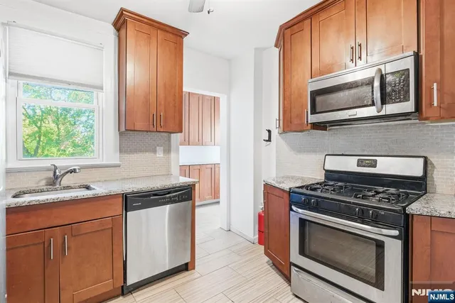 a kitchen with stainless steel appliances granite countertop a sink stove and microwave