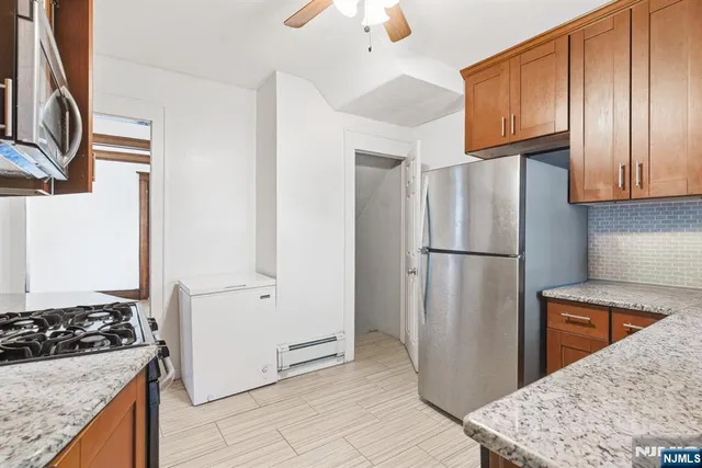 a kitchen with stainless steel appliances granite countertop a refrigerator and a stove