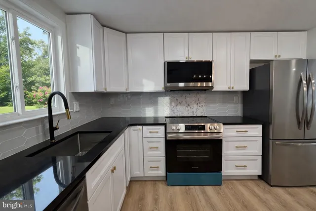 a kitchen with appliances a sink and a window