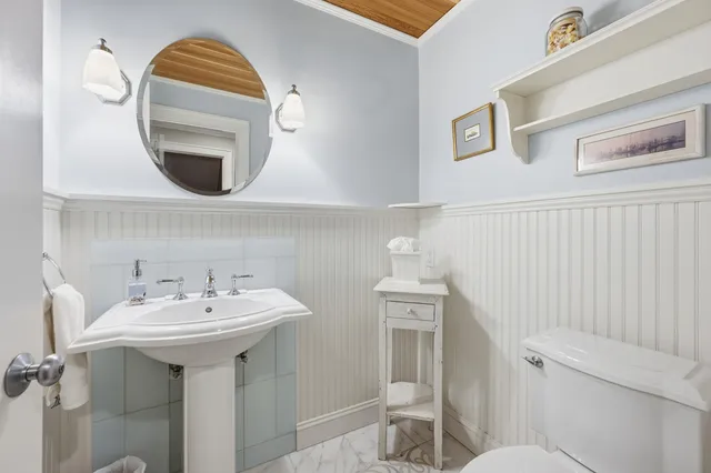 a bathroom with a toilet sink and mirror