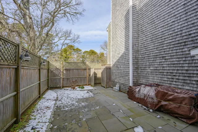 a view of a backyard with brick wall and potted plants