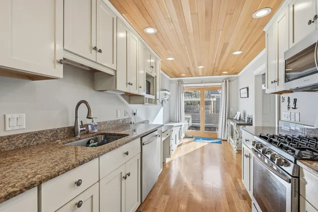 a kitchen with stainless steel appliances granite countertop a sink stove and cabinets