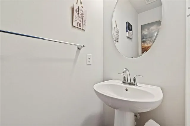 a bathroom with a sink a mirror and a lamp