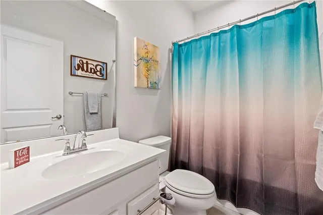 a bathroom with a sink a toilet and shower curtain