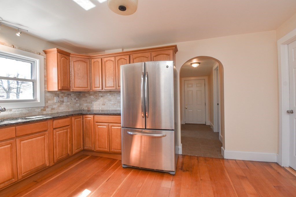 88 Dimmick Street Springfield, MA 01109 - Photo 11 of 36 a kitchen with granite countertop wooden floors and stainless steel appliances
