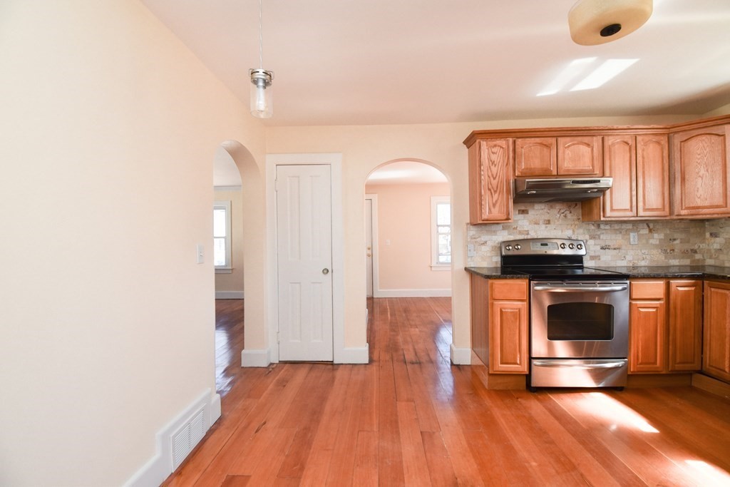 88 Dimmick Street Springfield, MA 01109 - Photo 12 of 36 a kitchen with granite countertop wooden floors and stainless steel appliances