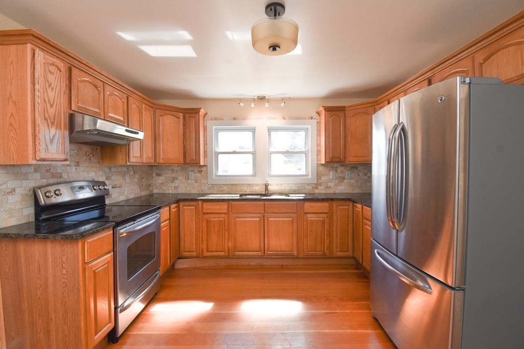 88 Dimmick Street Springfield, MA 01109 - Photo 7 of 36 a kitchen with stainless steel appliances granite countertop a refrigerator a sink dishwasher a stove and a refrigerator with wooden cabinets