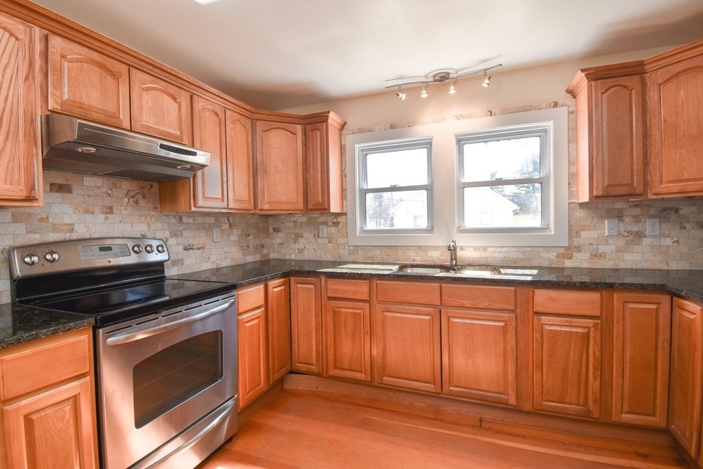 88 Dimmick Street Springfield, MA 01109 - Photo 8 of 36 a kitchen with granite countertop a stove sink and cabinets