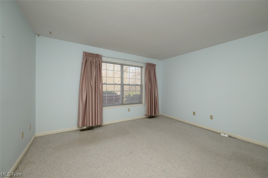 2231 Abbey Road Akron, OH 44312 - Photo 12 of 24 First floor master bedroom with walk-in closet, carpeted floors and access to first floor bath