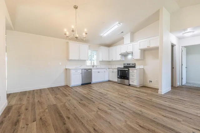 a view of kitchen with granite countertop cabinets and wooden floor