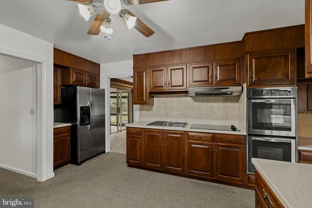 a kitchen with stainless steel appliances granite countertop a refrigerator and a stove top oven