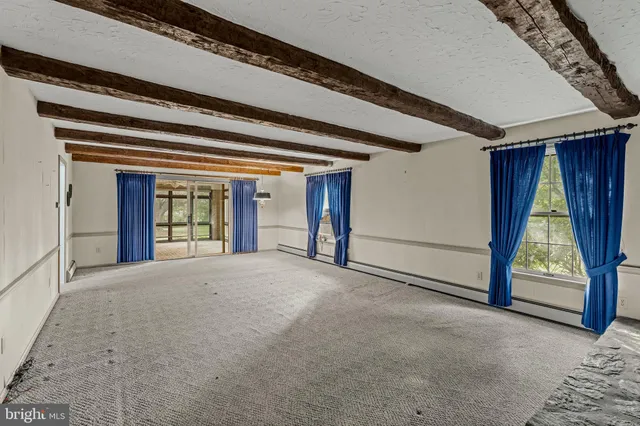 a view of an empty room with a fireplace and windows
