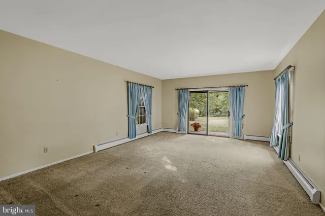 a view of a big room with windows and chandelier fan