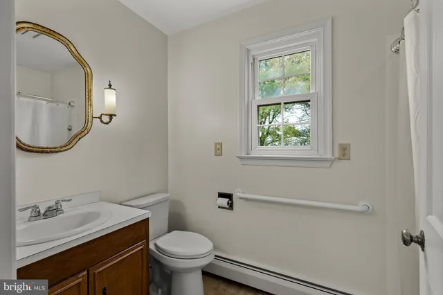 a bathroom with a granite countertop toilet sink and mirror