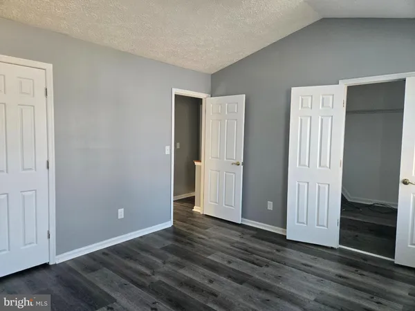 an empty room with wooden floor and closet