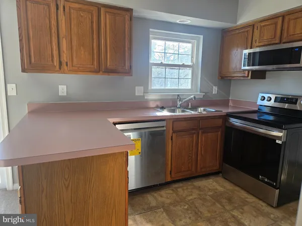 a kitchen with stainless steel appliances a stove a microwave sink and cabinets