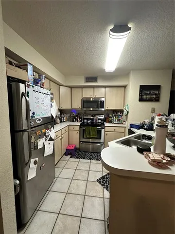 a kitchen with stainless steel appliances a stove a sink and a refrigerator