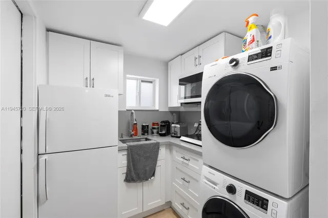 a view of a white house with a yard and potted plants