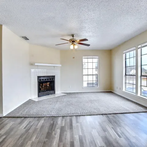 a view of an empty room with a fireplace and a window