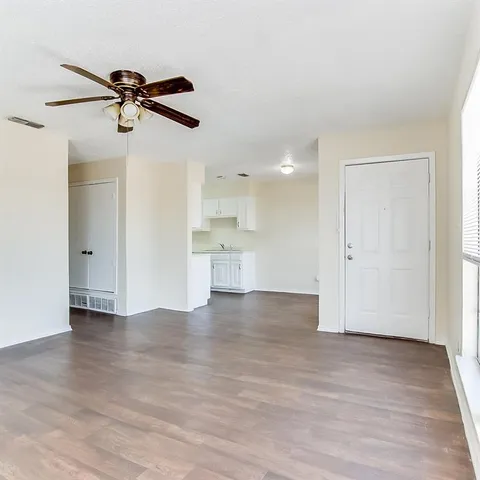 a view of empty room with wooden floor and windows