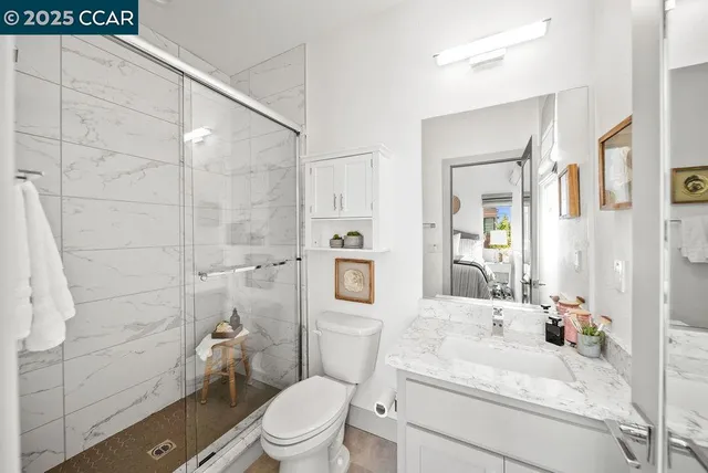 a bathroom with a sink toilet vanity and shower