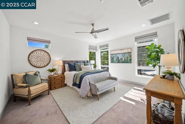 a spacious bedroom with a bed a couch and a chandelier