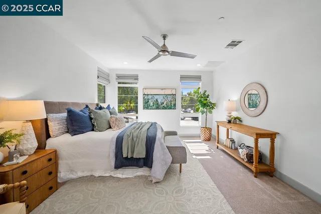 a living room with furniture ceiling fan and a large window