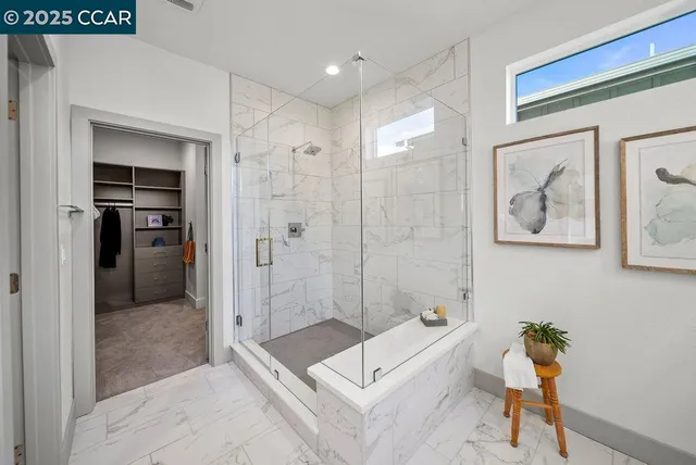 a bathroom with a tub shower and mirror
