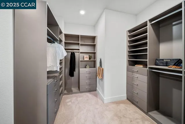 a view of walk in closet with clothes and shoes