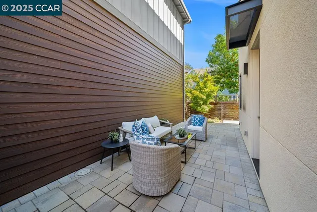a view of a patio with table and chairs and couches with wooden floor and fence