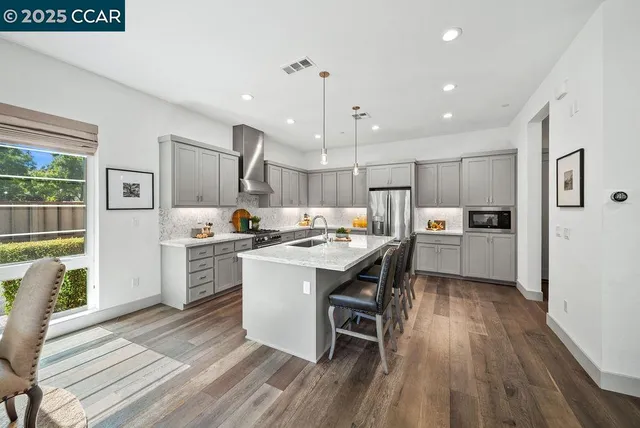 a kitchen with a sink a counter top space stainless steel appliances and a window