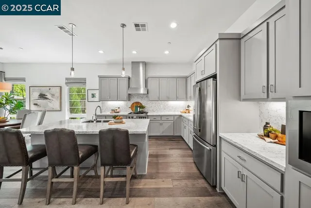a kitchen with refrigerator cabinets dining table and chairs