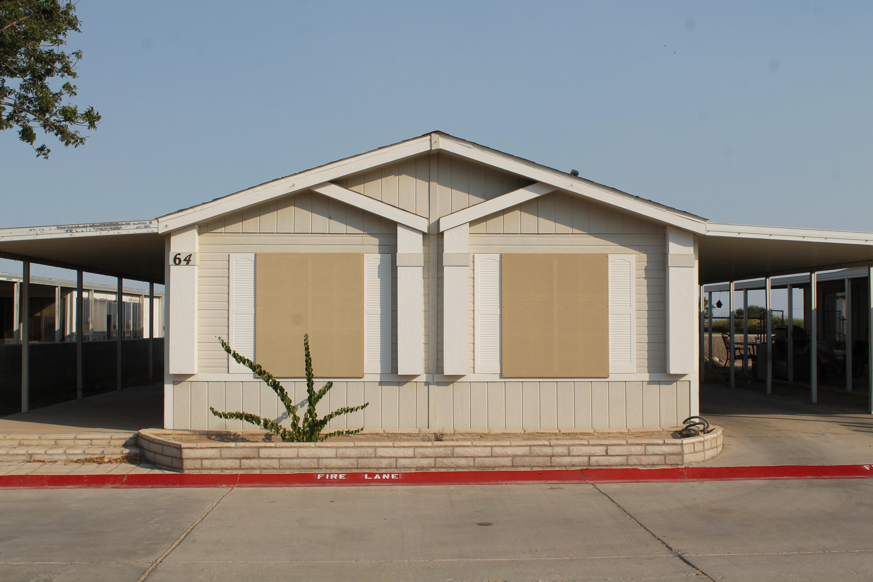 3589 West Wells Road, Unit 64 Blythe, CA 92225 - Photo 1 of 15 a front view of a house with a yard and garage