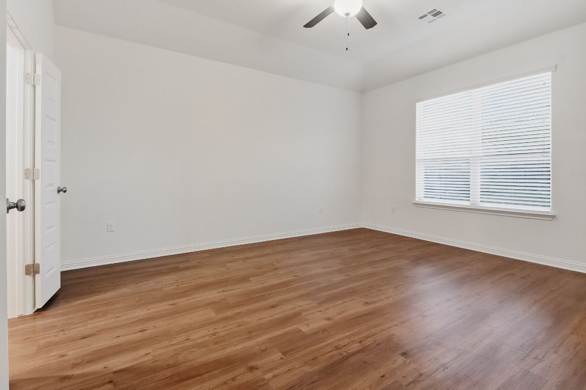 8001 Dampton Lane Austin, TX 78744 - Photo 11 of 38 wooden floor in an empty room with a window