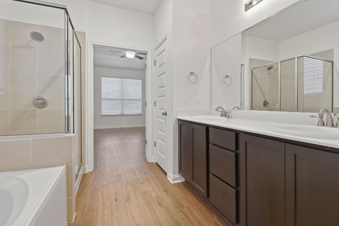 8001 Dampton Lane Austin, TX 78744 - Photo 16 of 38 a bathroom with a double vanity sink a large mirror and shower