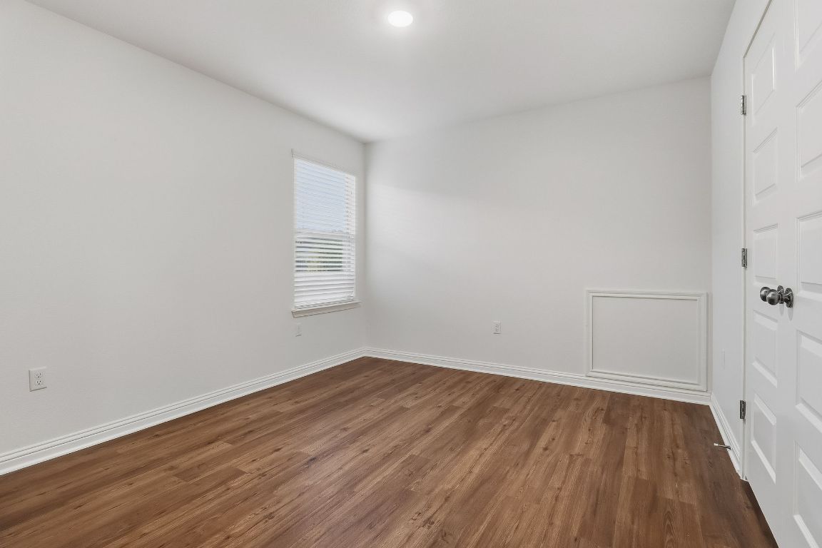8001 Dampton Lane Austin, TX 78744 - Photo 24 of 38 an empty room with wooden floor and windows