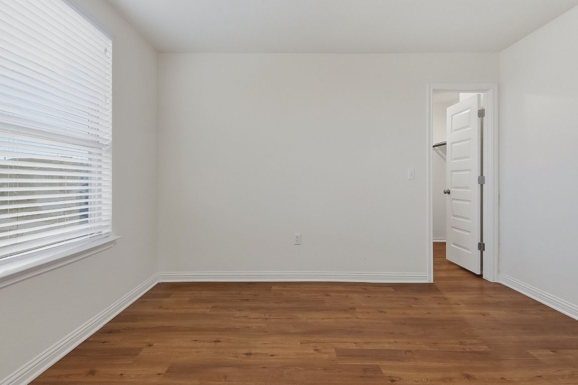 8001 Dampton Lane Austin, TX 78744 - Photo 30 of 38 a view of an empty room with wooden floor and a window
