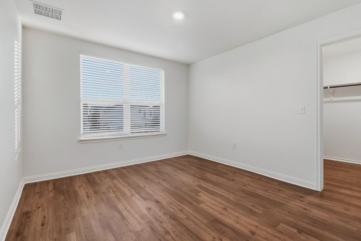 8001 Dampton Lane Austin, TX 78744 - Photo 31 of 38 a view of an empty room with wooden floor and a window