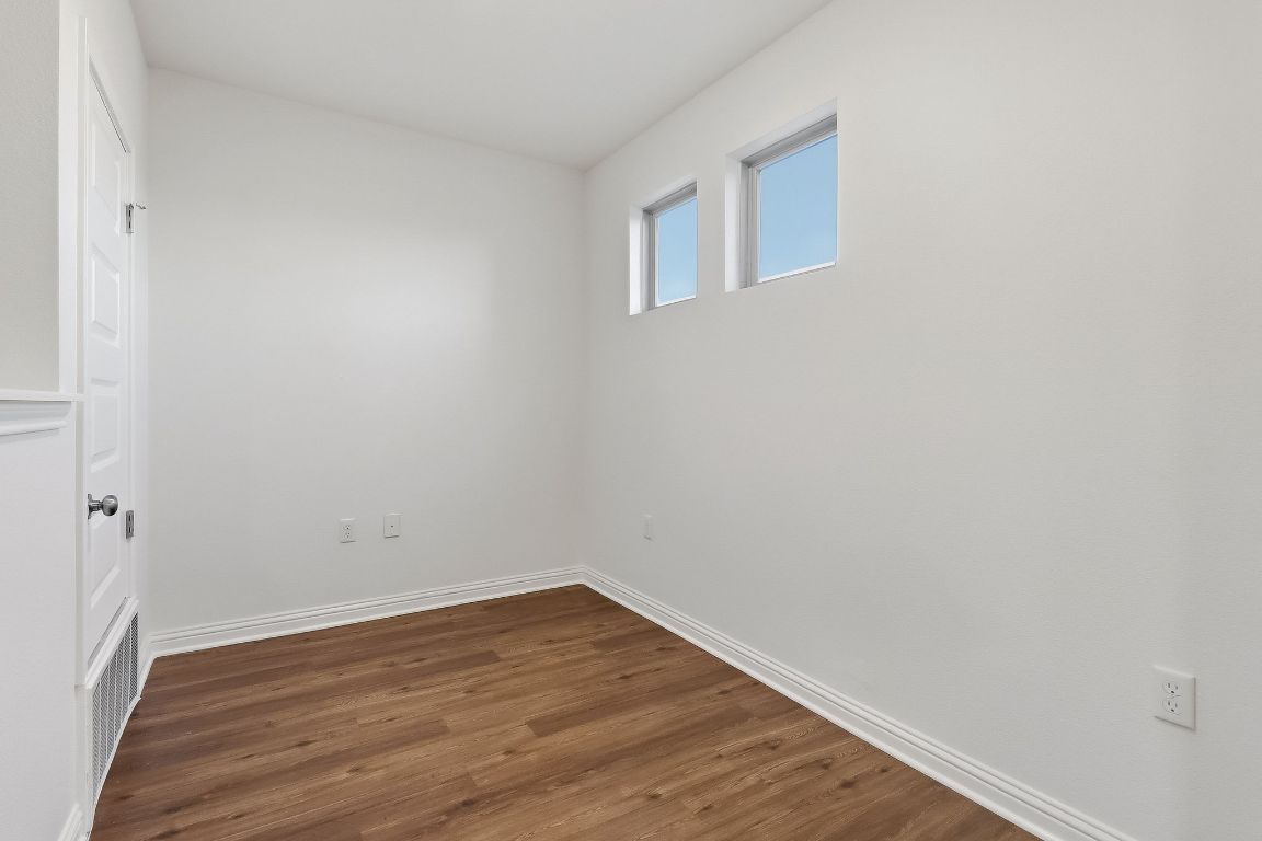 8001 Dampton Lane Austin, TX 78744 - Photo 33 of 38 a view of an empty room with wooden floor and a window