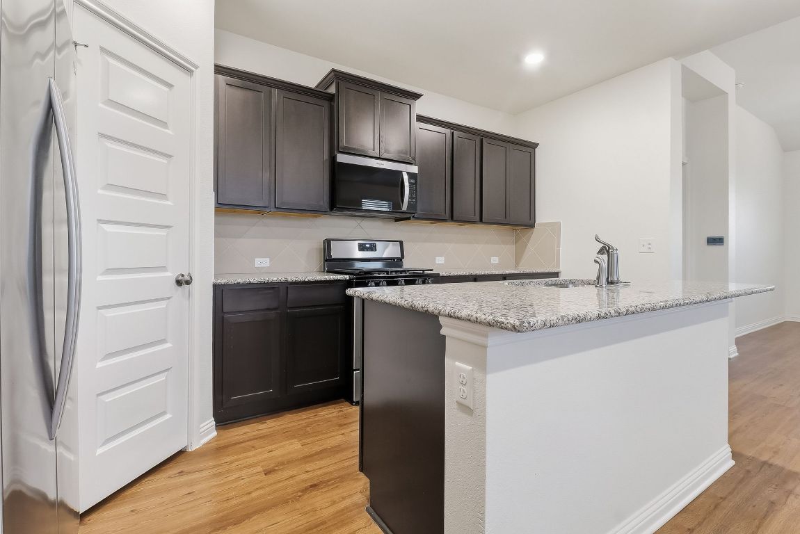 8001 Dampton Lane Austin, TX 78744 - Photo 7 of 38 a kitchen with stainless steel appliances granite countertop a refrigerator and a stove top oven