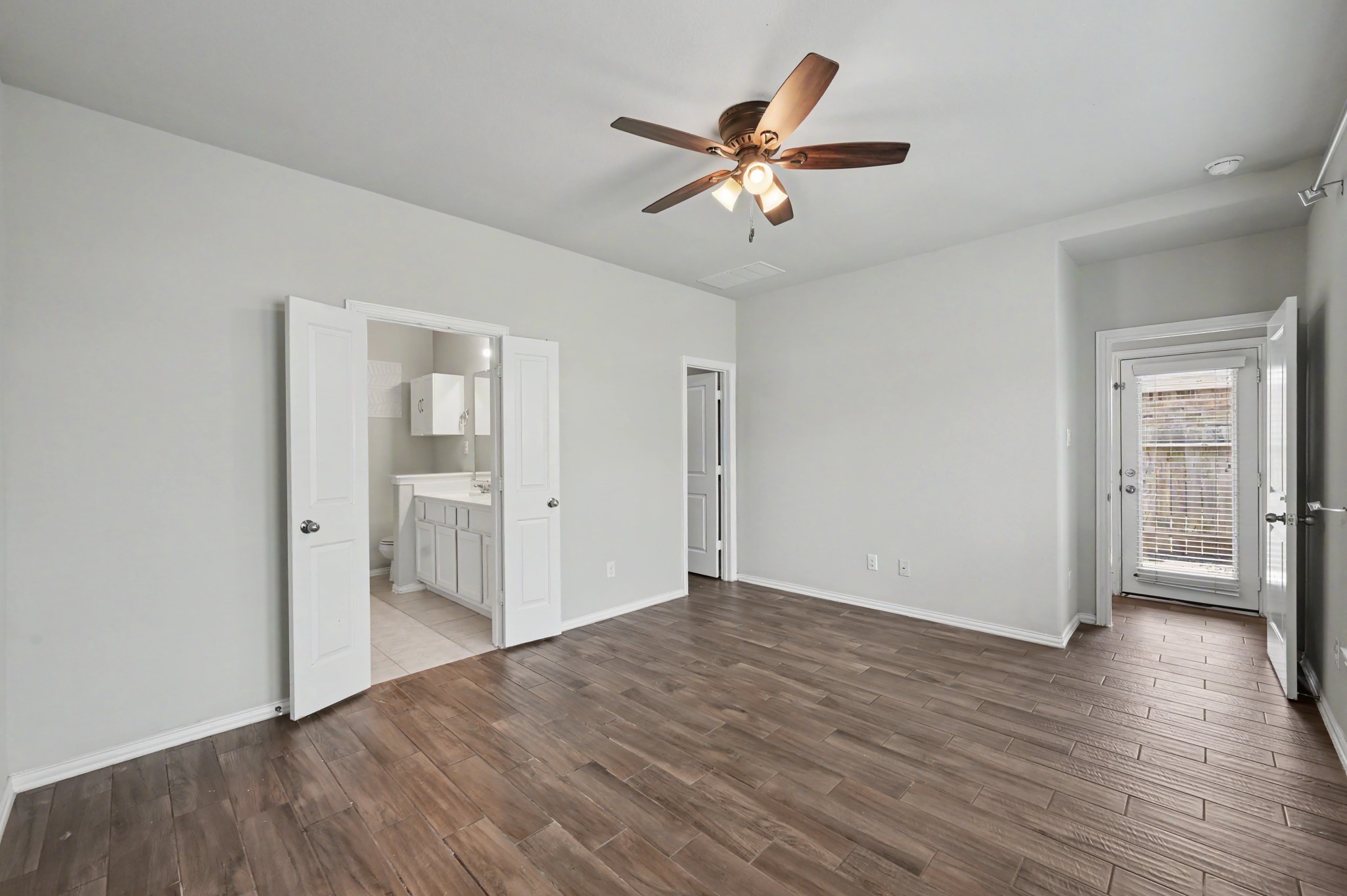 29836 Woodsons Edge Way Spring, TX 77386 - Photo 15 of 38 Alternate view of the primary bedroom, with double French doors leading into the ensuite bathroom.