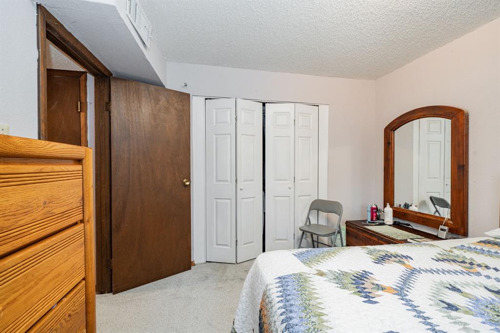 2712 Kleberg Road, Unit B Seagoville, TX 75159 - Photo 21 of 40 Bedroom with light colored carpet, a textured ceiling, and a closet