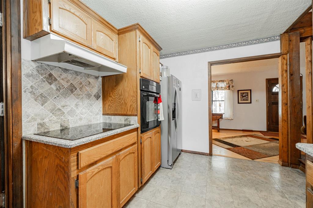 2712 Kleberg Road, Unit B Seagoville, TX 75159 - Photo 6 of 40 Kitchen featuring a textured ceiling, black appliances, light stone counters, and decorative backsplash